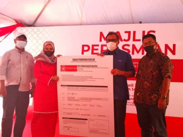 Abdul Rashid (dua dari kanan) menerima replika borang keahlian daripada Maini (dua dari kiri) pada Majlis Perasmian PKK Bersatu Bahagian Kuala Selangor dan Penyerahan Sumbangan Ihya Ramadan D'Manis di pekarangan PKK Bersatu Bahagian Kuala Selangor pada Sabtu.