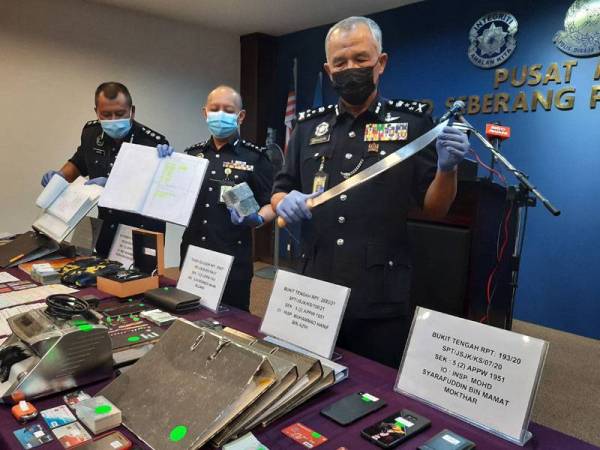 Zainuddin menunjukkan parang dan barangan lain yang dirampas dari keempat-empat sindiket ah long tersebut.