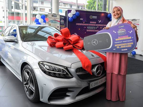 Pemenang tempat pertama Hadiah Cabutan Wow! SSPN-i Plus Tahunan 2020 Sonita Sudin bergambar bersama kereta Mercedes Benz C200 FL AMG Line yang dimenanginya pada Majlis Penyampaian Hadiah Cabutan Wow! SSPN-i Plus Tahunan 2020 di Nz Whells Bangsar hari ini.