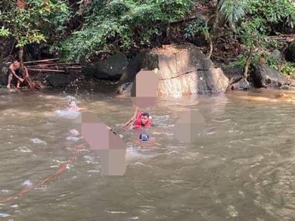 Anggota bomba membawa mangsa setelah ditemui pada kedalaman 2.5 meter di Air Terjun Batu Berangkai. - Foto Ihsan bomba.