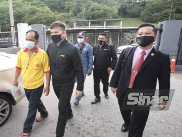 Tertuduh (kiri) diiringi pegawai SPRM sewaktu hadir di Mahkamah Sesyen Johor Bahru, pada Isnin.