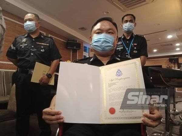 Aizuddin menunjukkan sijil penghargaan yang diterimanya.