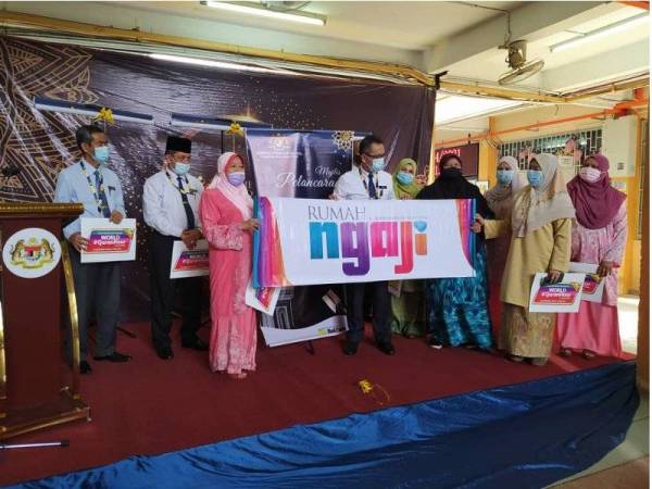 Normah Hanum (kiri) menyerahkan gegantung Rumah Ngaji kepada Mohamad Fauzi selepas melancarkan Rumah Ngaji JPN Perak sempena Program Ihya Ramadan di Pejabat JPN Perak, pada Isnin.