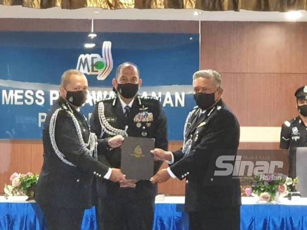 Mior Faridalathrash (tengah) menyaksikan serah terima tugas antara Ahmad Adnan (kiri) dengan Mohamad Roy sebagai Ketua Polis Daerah Batu Gajah.