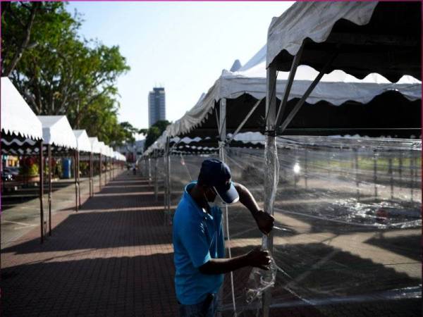 Pekerja memasang dinding plastik lut sinar antara gerai di Bazar Ramadan Taman Kerang,Kuantan menjelang tibanya Ramadan esok pada tinjauan pada Isnin.