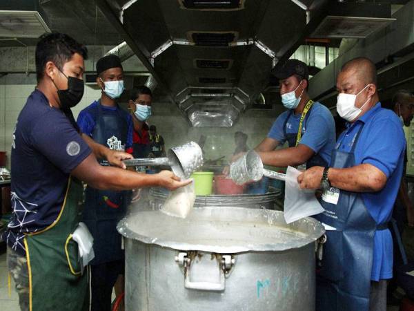 Pekerja membungkus bubur lambuk sebelum diberi kepada orang ramai ketika tinjauan di Masjid Jamek Kampung Baru hari ini. - Foto Bernama