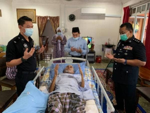 Ganti (kiri) mengaminkan doa semasa menziarah ke rumah Sarjan Mejar Basri Darus iaitu Bekas Timbalan Ketua Polis Balai Pengkalan Kubor yang kini terlantar akibat kanser prostat.