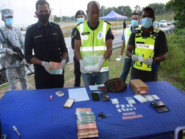 Hanyan (tengah) menunjukkan antara barangan yang dirampas semasa sidang akhbar di lokasi SJR Perasing, Kemaman pada petang Isnin