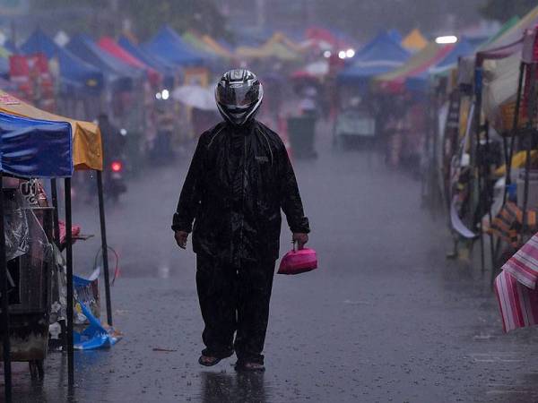 Pengunjung dilihat memakai baju hujan dan topi keledar semasa membeli juadah berbuka puasa dalam keadaan hujan di Bazar Ramadan Kampung Baru pada hari pertama Ramadan hari ini.
