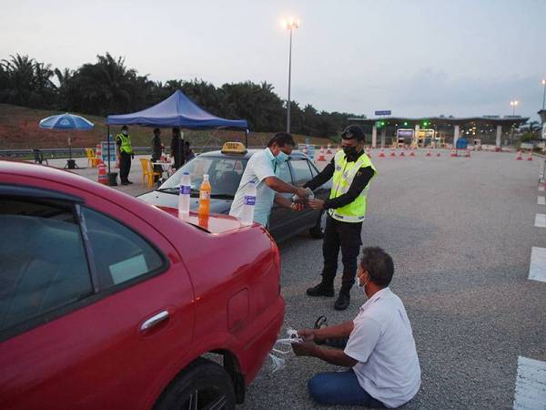 Anggota pasukan barisan hadapan berkongsi juadah berbuka puasa dengan orang awam yang mengalami kerosakan kenderaan di Sekatan Jalan Raya (SJR) Tol Kuantan pada hari pertama berpuasa hari ini.