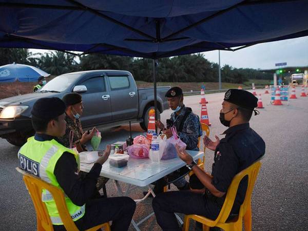 Anggota pasukan barisan hadapan mengaminkan doa berbuka puasa bersama-sama ketika bertugas di Sekatan Jalan Raya (SJR) Tol Kuantan pada hari pertama berpuasa hari ini.