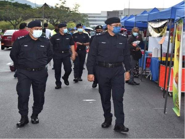 Mohd Fazley (kanan) melakukan Ops Pematuhan SOP di bazar Ramadan Bandar Baru Nilai pada Selasa.