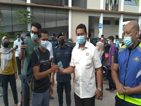 Mohd Haffiz (dua dari kanan) mengedarkan kupon kepada pengunjung Bazar Ramadan Nusa Perintis pada Rabu.