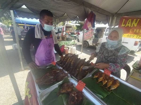 Roslan dan isterinya, Jamaliah Ramli, 46, mengamalkan pemakaian pelitup muka serta mematuhi SOP ditetapkan di bazar Ramadan Stadium Darul Aman, Alor Setar pada Selasa.