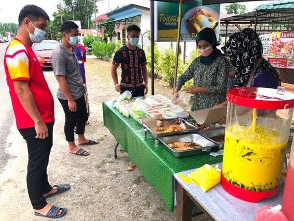 Zaquan Adha Abdullah, 39, (kiri) membeli juadah sebagai persiapan berbukua puasa bersama-sama rakannya di Institut Dakwah Islamiah Perkim (IDIP) di Pengkalan Chepa, Kota Bharu.
