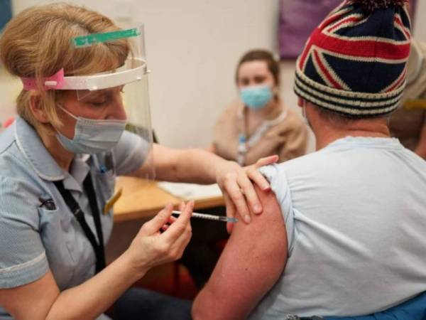 Seorang lelaki (kanan) menerima suntikan vaksin Pfizer-BioNTech di Newcastle, Britain baru- baru ini - Foto AFP