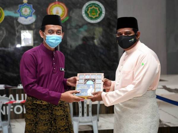Mohd Zawawi (kiri) menyerahkan agihan kurma kepada Ketua Divisyen Operasi Agihan, Abdul Basith Hamid pada Majlis Agihan Kurma Kepada Agensi-Agensi Islam di Jabatan Agama Islam Selangor (JAIS) di Shah Alam pada Jumaat. Foto Bernama