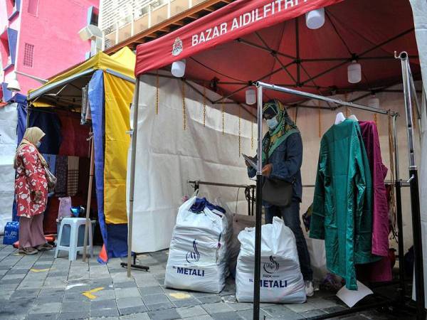 Peniaga melakukan persiapan sebelum memulakan perniagaan di Bazar Aidilfitri di Lorong Tuanku Abdul Rahman hari ini, yang telah beroperasi semula setelah ditangguhkan pelaksanaannya pada 2020 berikutan penularan COVID-19. - Foto Bernama
