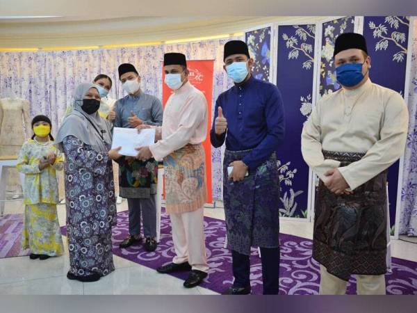 Datuk Seri Mohamed Faroz Mohamed Jakel (kanan) menyampaikan sumbangan kepada wakil guru dari Sekolah Menengah Kebangsaan Pendidikan Khas Setapak bersama barisan duta produk Jakel.