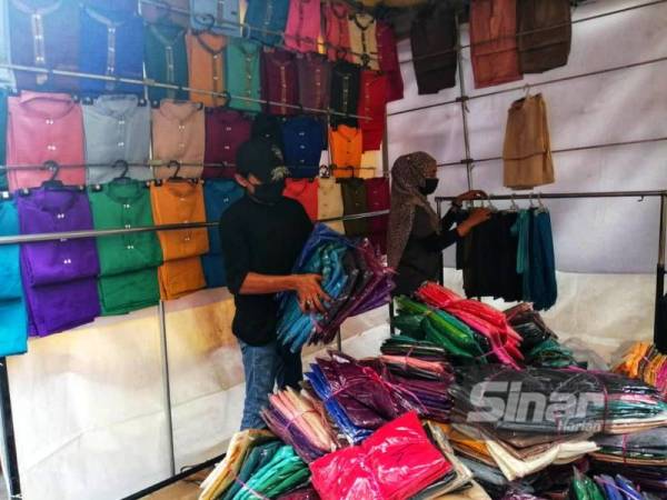 Peniaga sedang membuat persiapan pada hari pertama Bazar Aidilfitri Lorong TAR di Kuala Lumpur beroperasi pada Sabtu.