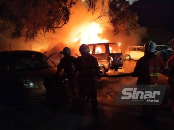 Anggota bomba sedang memadamkan api dalam kebakaran membabitkan empat buah kenderaan pada awal pagi Ahad.