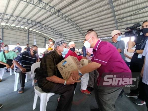 Saarani menyampaikan bantuan kotak makanan kepada seorang mangsa yang terjejas dalam kejadian ribut di Kampung Tasek, Ipoh.