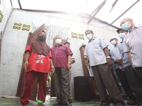 Hatiah (kiri) menerima kunjungan Saarani di rumahnya di Kampung Tasek, Ipoh pada Ahad.