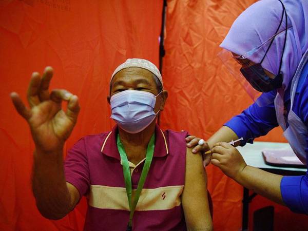 Warga emas Mat Nor Jusoh,79, menerima suntikan vaksin Pfizer-BioNTech pada hari pertama fasa kedua Program Imunisasi COVID-19 Kebangsaan di Wisma Belia, hari ini.