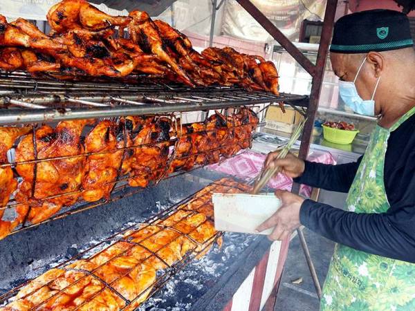 Peniaga Nordin Arshad, 58 memanggang ayam golek sebelum dijual kepada pelanggannya di Kampung Sukamari di sini hari ini.