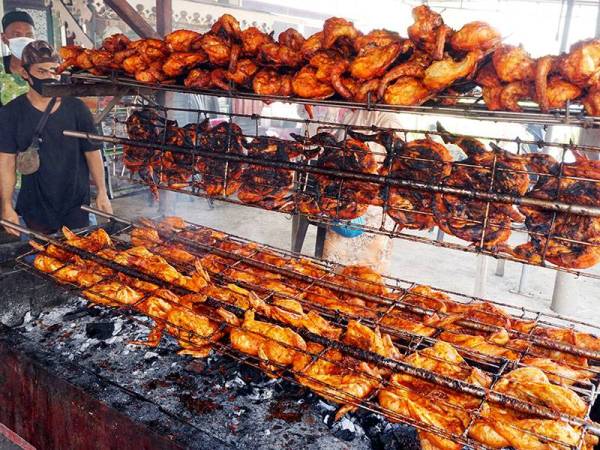 Susunan ayam golek yang siap dibakar Nordin Arshad, 58, (belakang) sebelum dijual kepada pelanggannya Kampung Sukamari di sini hari ini.