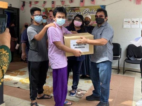 Ibrahim (kanan) menyampaikan Sumbangan Prihatin sempena Ramadan kepada kanak-kanak istimewa pada majlis di Seksyen 3, Shah Alam baru-baru ini.
