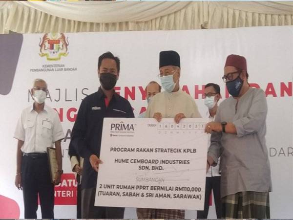 Abd Latiff (dua dari kanan) bersama Dr Mahathir (dua dari kiri) menyerahkan cek kepada Hume Cembord Industries Sdn Bhd pada Majlis Penyerahan dan Penghargaan Rakan Strategik KPLB di perkarangan Masjid Al-Ehsan, Temonyong di sini pada Jumaat.