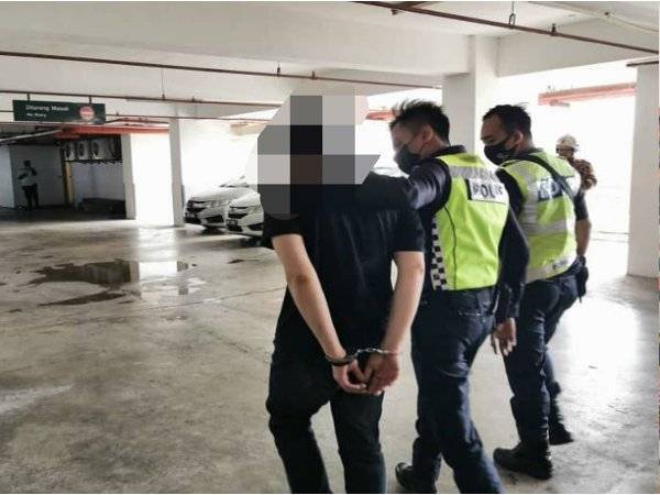 Polis menenangkan lelaki yang cuba terjun dari sebuah plaza di Taman Abad, Johor Bahru, petang Isnin. - Foto Ihsan bomba