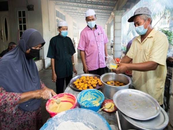 Mohd Huzaimy (dua dari kanan) beramah mesra dengan pengusaha akok dan nekbat terkenal, Ibrahim Yunus, 57, (kanan) pada Program Lawatan Pengusaha Kuih-Muih Kelantan di Kampung Merabang pada Selasa. Foto Bernama
