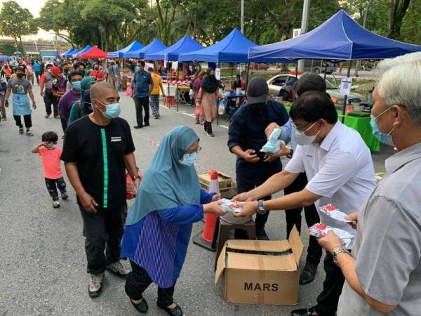 Izhar menyampaikan sumbangan kit sanitasi dan wang tunai kepada pengunjung di Bazar Ramadan Kampung Melayu Majidee, Johor Bahru pada Selasa.