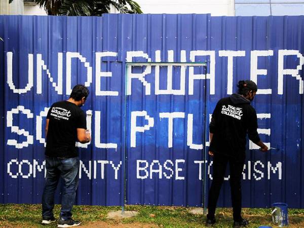 Pelukis doodle Wan Muhammad Huzaifah Wan Basir, 22 (kanan) dan Muhammad Hizami Musa, 34, melakukan kerja-kerja bagi menyiapkan lukisan doodle pada pagar penghadang 'hoarding' di Balai Seni Negara hari ini.