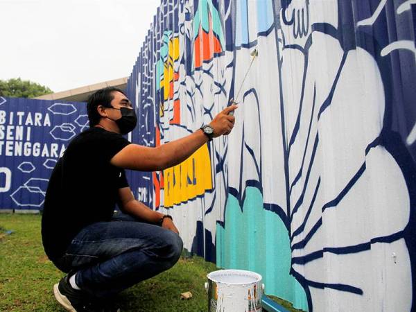 Pelukis doodle, Muhammad Hizami Musa, 34, melakukan kerja-kerja bagi menyiapkan lukisan doodle pada pagar penghadang 'hoarding' di Balai Seni Negara hari ini.