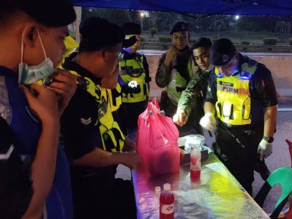 Petugas barisan berbuka puasa dengan juadah yang ditaja oleh Pusat Pakaian Hari-Hari dan Sinar Harian di SJR Tol Gombak pada Rabu.