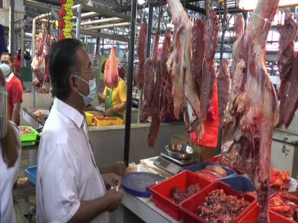 Ismail turut melihat harga yang dipaparkan penjual daging di pasar itu.