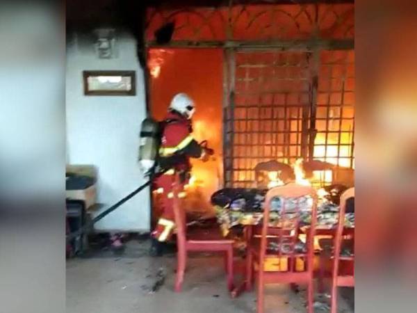 Anggota bomba memadam kebakaran membabitkan sebuah rumah di Taman Desa, Kluang pada Khamis.