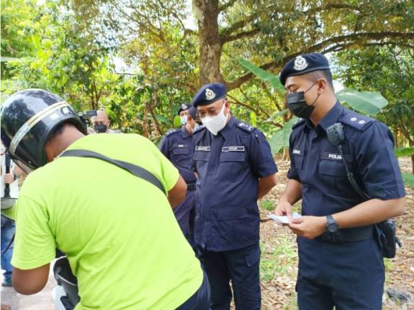 Shafien (dua dari kanan) mendengar alasan daripada seorang pemuda yang sanggup merentas negeri ke Terengganu untuk membeli air soya di Pasir Puteh pada Jumaat.