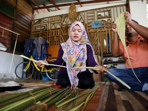 Peniaga, Norazira Mohammad Salleh, 33 (kiri) bersama suami, Mohammad Solleh Abdullah Hamid, 30 (kanan) membuka daun palas minyak ketika tinjauan di rumah mereka hari ini.