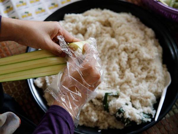 Beras pulut diisi ke dalam daun palas minyak ketika tinjauan hari ini.