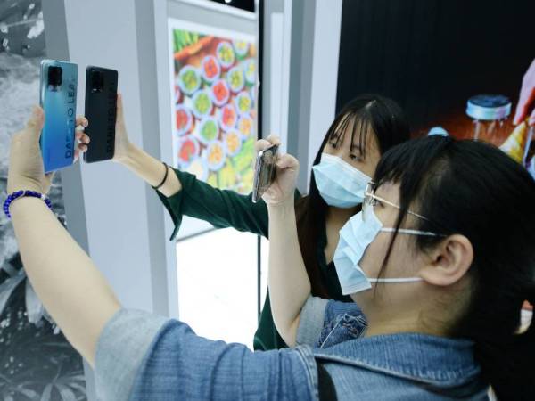 Dua pengunjung menggunakan telefon pintar realme untuk mengambil gambar.