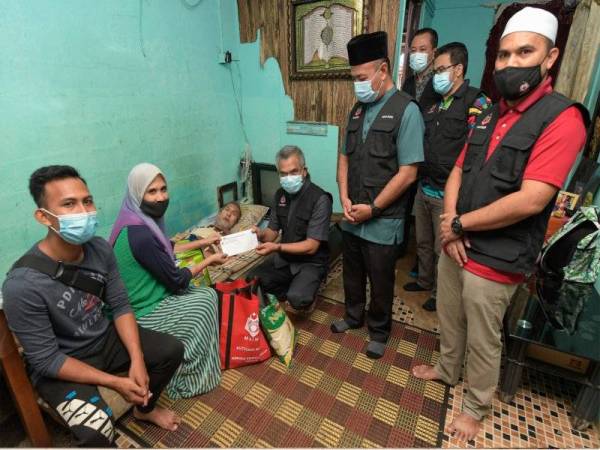 Mohd Daud menyampaikan sumbangan wang tunai serta barangan keperluan asas kepada Wan Nor Fazilah serta bapanya, Muhammad Saad Muhd Ramli pada program Jejak Asnaf Siri 1 di kediaman mereka di sekitar kawasan Setapak pada Sabtu.