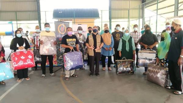 Zamri (empat dari kiri) bersama mangsa ribut yang menerima sumbangan berupa keperluan rumah daripada Yayasan Ikhlas dengan kerjasama Isma Cawangan Ipoh dalam satu majlis ringkas di di Kampung Tasek pada Sabtu.