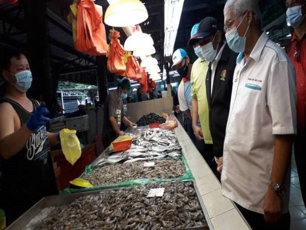 Hassan (kanan) melakukan tinjauan harga barang basah di Kipmall Masai, Pasir Gudang pada Sabtu.