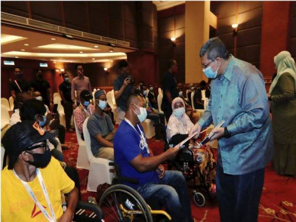 Saifuddin yang juga Ahli Parlimen Indera Mahkota (kanan) menyampaikan sumbangan kepada OKU pada Program Sumbangan Ramadan kepada Persatuan OKU, pada Sabtu.
Foto: Bernama (2021) Hak Cipta Terpelihara