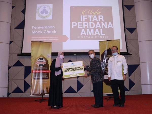 Wakil Badan Kebajikan Islam Telekom Malaysia (Bakit), Azni Risa Razlan (kiri) menyerahkan replika cek berjumlah RM5,000 kepada Pengerusi HCF, Muhammad Fuad Yeoh Abdullah di Dewan Kristal TMCC pada Sabtu.