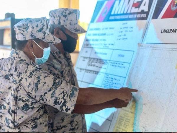 Pengarah Maritim Malaysia Kelantan, Kepten Maritim Muhd Nur Syam Asmawie Yaacob (kanan) menunjukkan peta kawasan pencarian mangsa yang masih hilang, Zulshahmi.